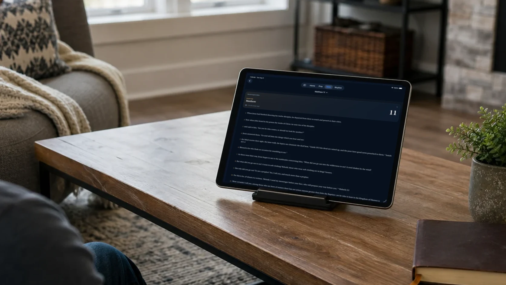 An adult reading the Pray Shield Bible on an iPad in a quiet living room